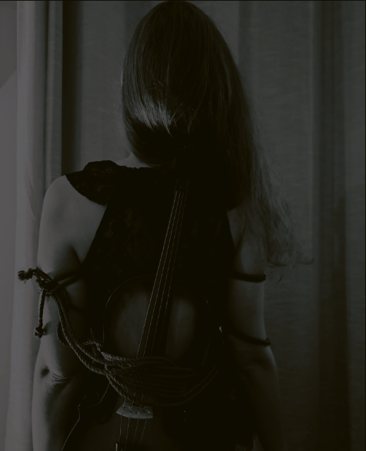 A woman with a violin tied with jute ropes on her body